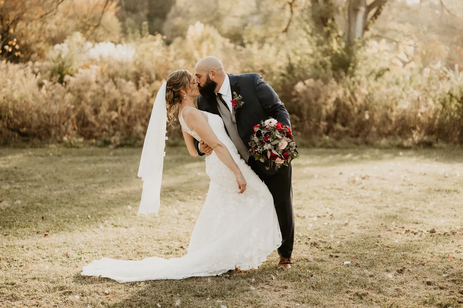 Amanda and Rick kissing in a golden autumn meadow