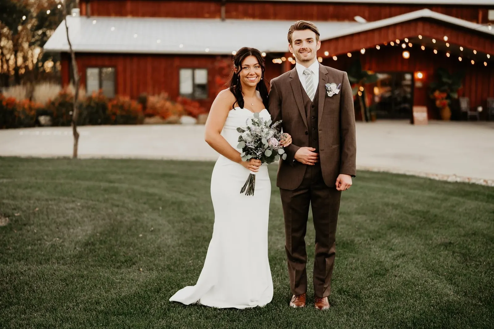 Ethan and Gwyn in front of a red barn venue