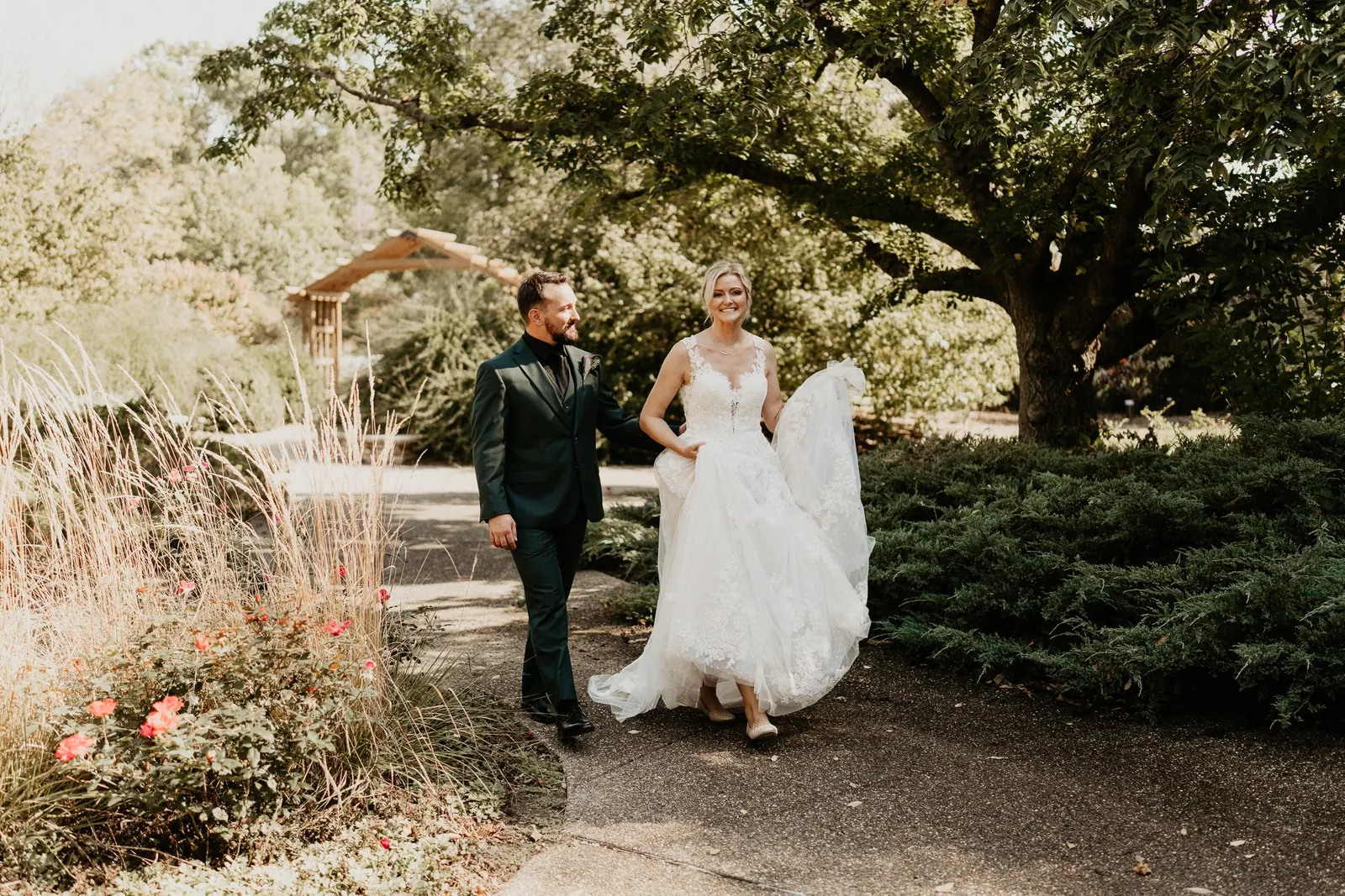 Kelly and Adam walking through a sunlit garden